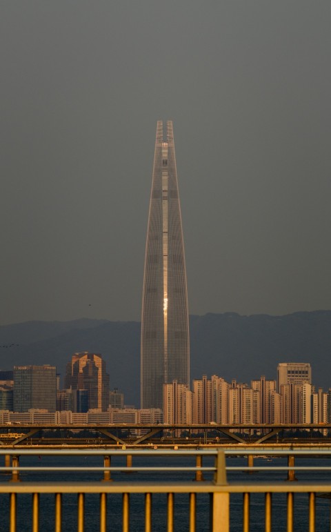 a plane flying over a city with tall buildings