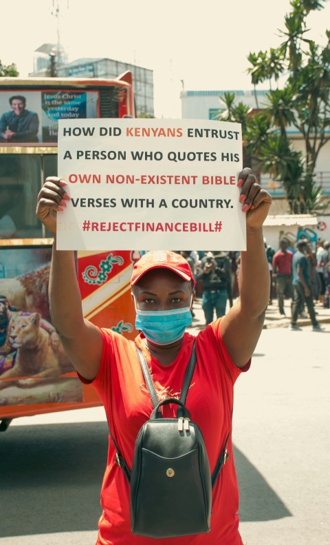 a person wearing a face mask holding a sign