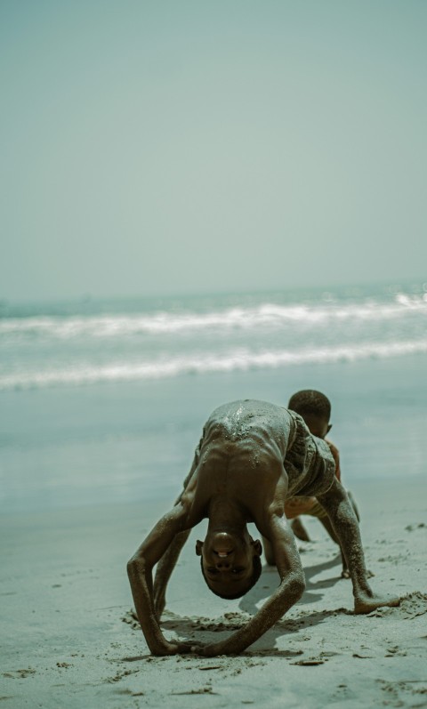 two children playing in the sand at the beach