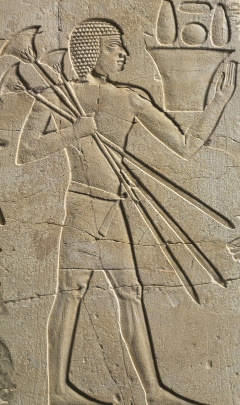 an ancient egyptian carving of a man holding a staff