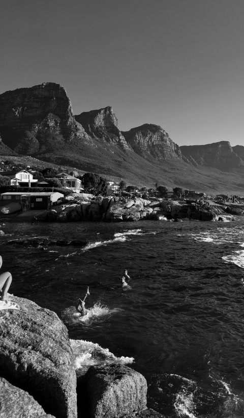 a black and white photo of people swimming in the ocean rrIgVQ_I