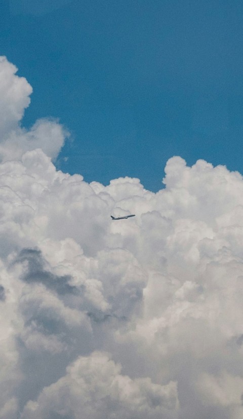 a plane is flying through the clouds on a sunny day USMYG