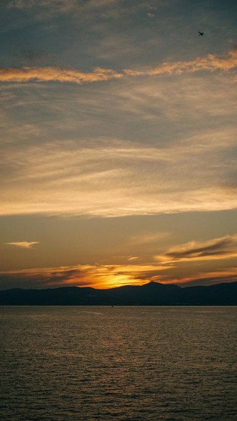 a large body of water with a sunset in the background