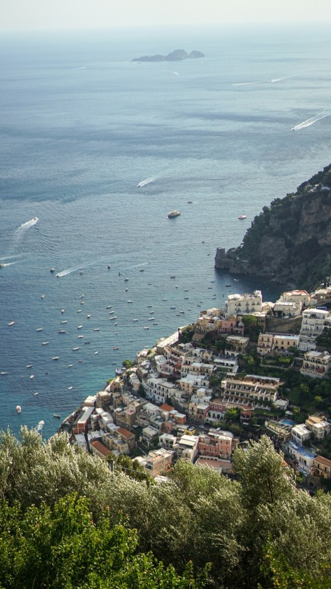 a scenic view of a town on a cliff overlooking the ocean