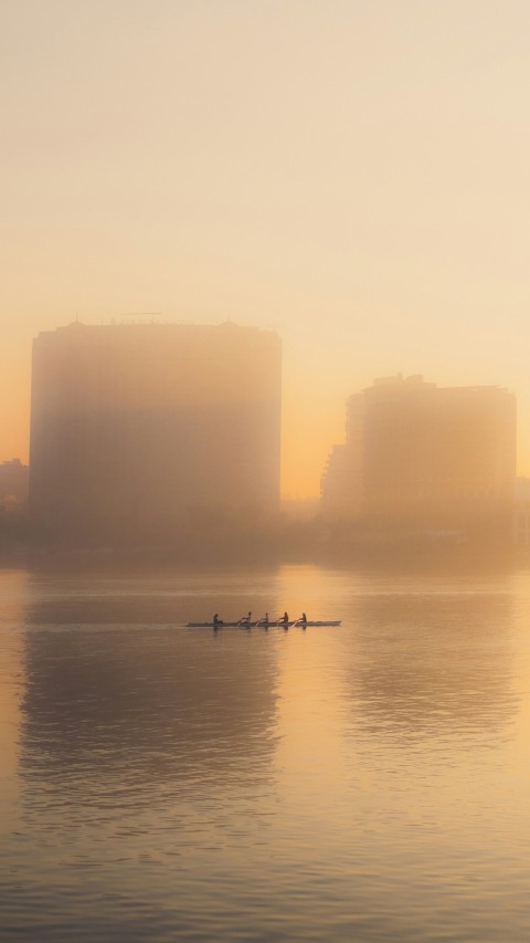 a group of people rowing a boat on a body of water