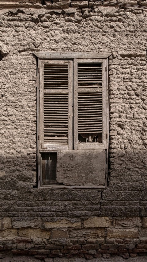 a cat sitting in the window of a stone building