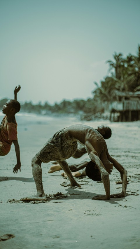 a couple of men standing on top of a sandy beach