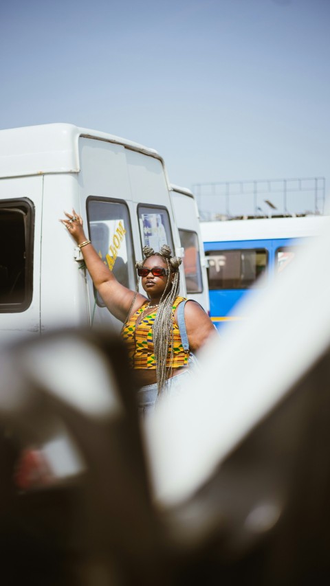 a woman standing in front of a white bus