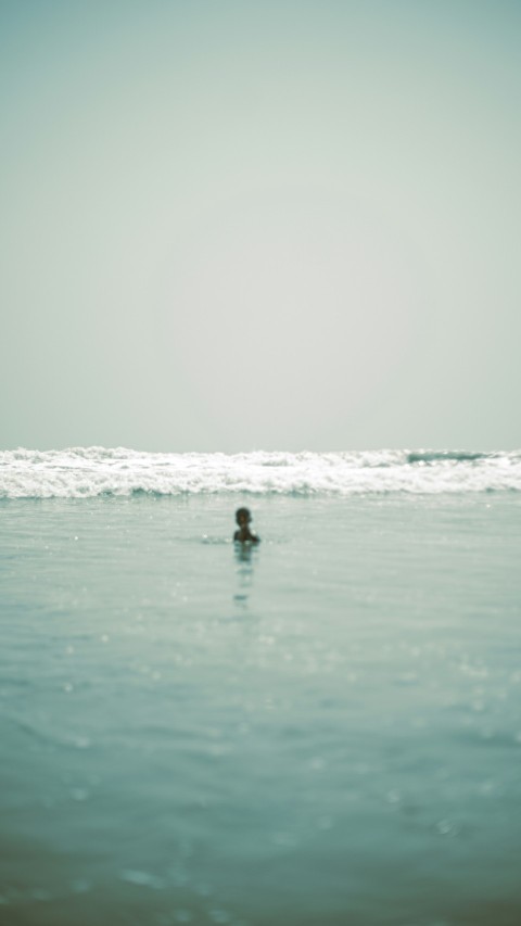 a person swimming in the ocean on a sunny day