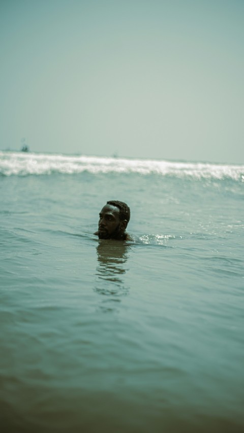 a man swimming in the ocean with his head above the water P01