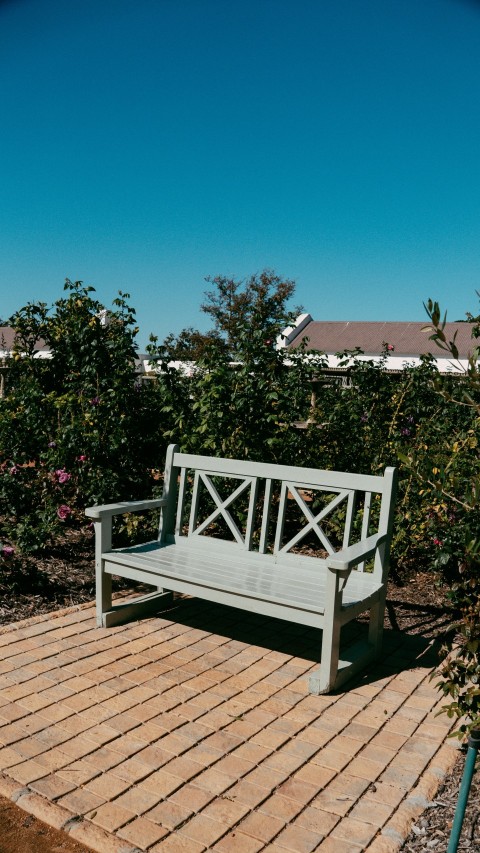 a wooden bench sitting on top of a brick patio