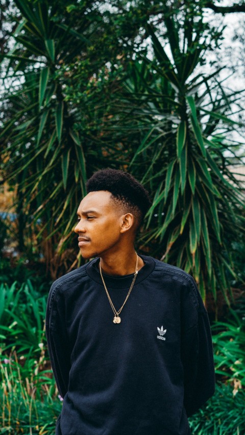 a man standing in front of some plants