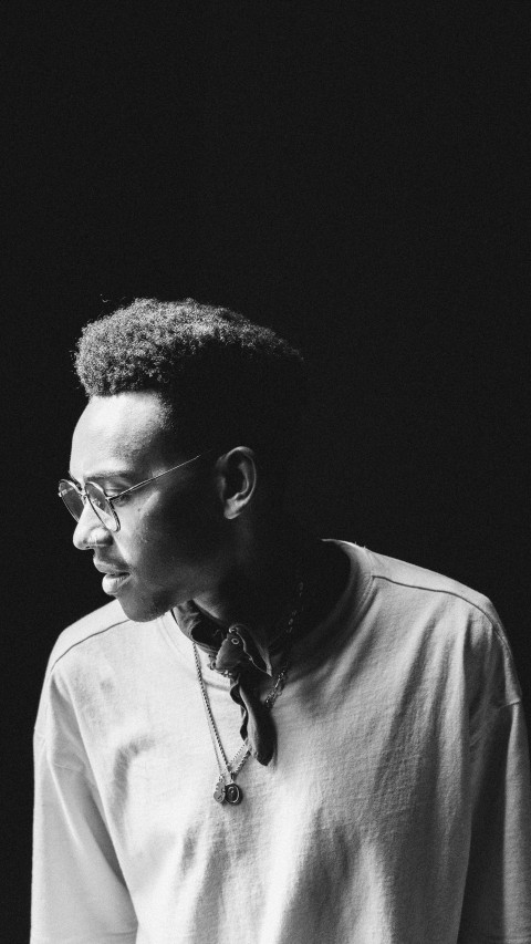 a black and white photo of a man wearing glasses