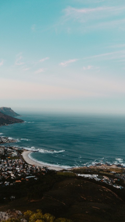 a view of a city and the ocean from a hill