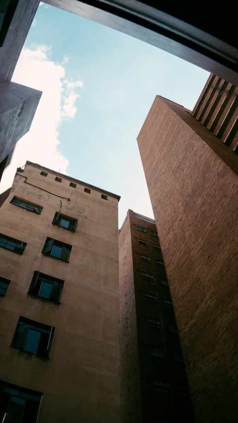 looking up at two tall buildings in a city