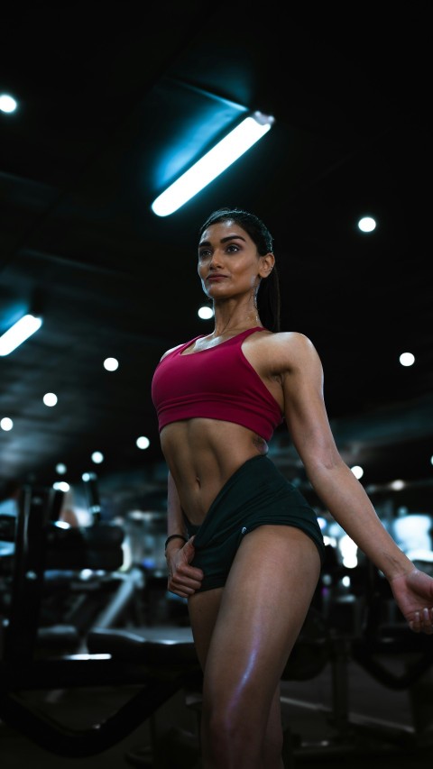 a woman in a red top and green skirt in a gym