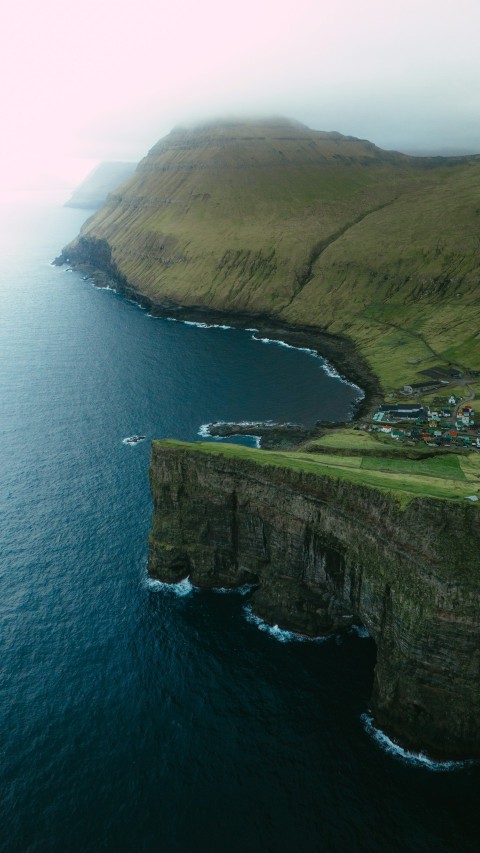 a large body of water near a lush green hillside