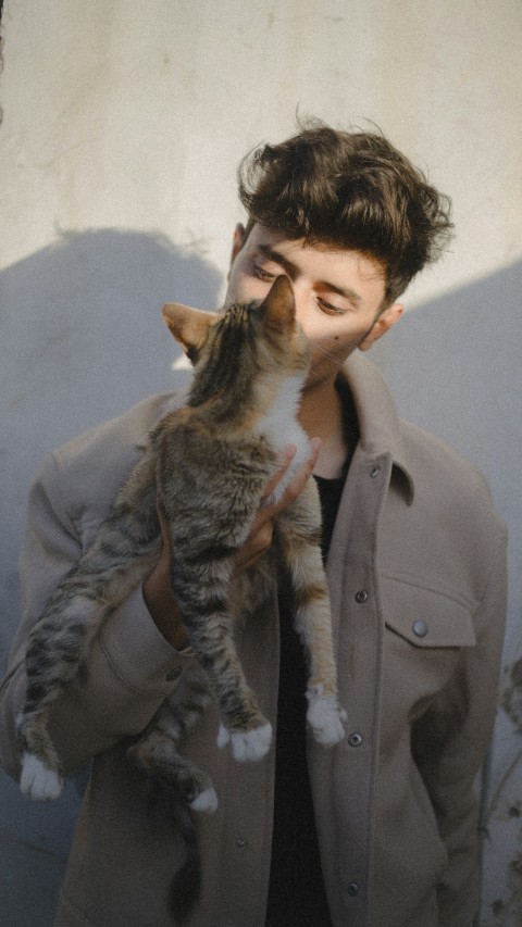 a man holding a cat up to his face