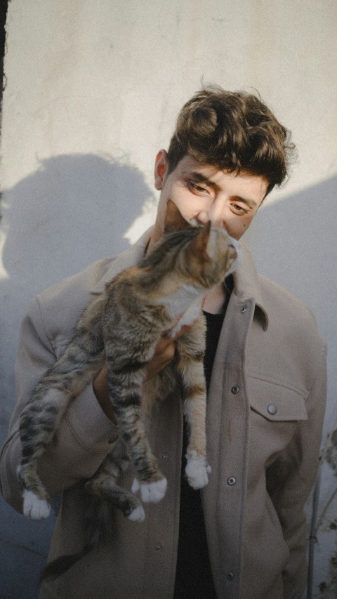 a man holding a cat in his hands