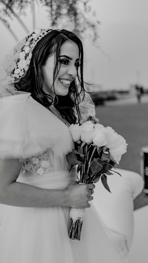 a person in a white dress holding flowers