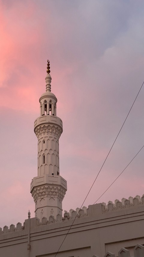 a tall white tower with a clock on its side