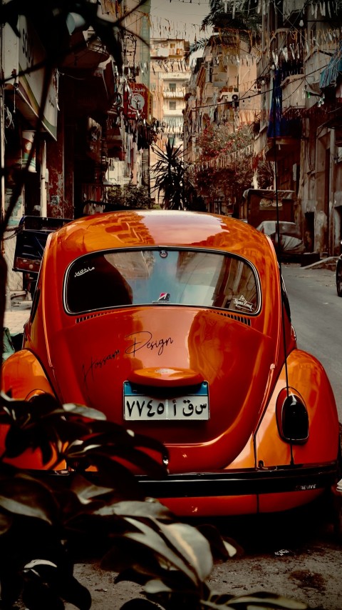 an orange car parked on the side of the road