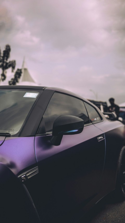 a purple car with a person in the background