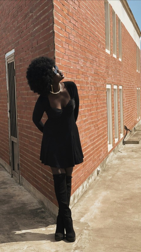 a woman standing in front of a brick building