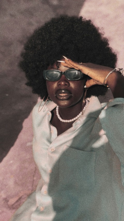 a woman wearing sunglasses and a white shirt