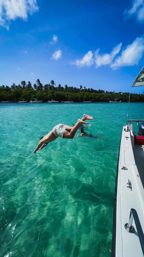 woman in white and blue polka dot bikini lying on white boat on sea during daytime