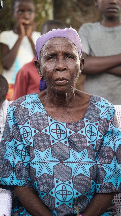 a woman in a blue dress sitting in front of a group of people