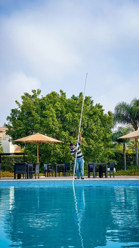 man in black and white stripe shirt standing on swimming pool during daytime