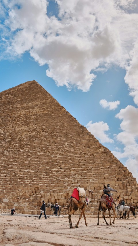 people riding camels by pyramid during daytime IoMr