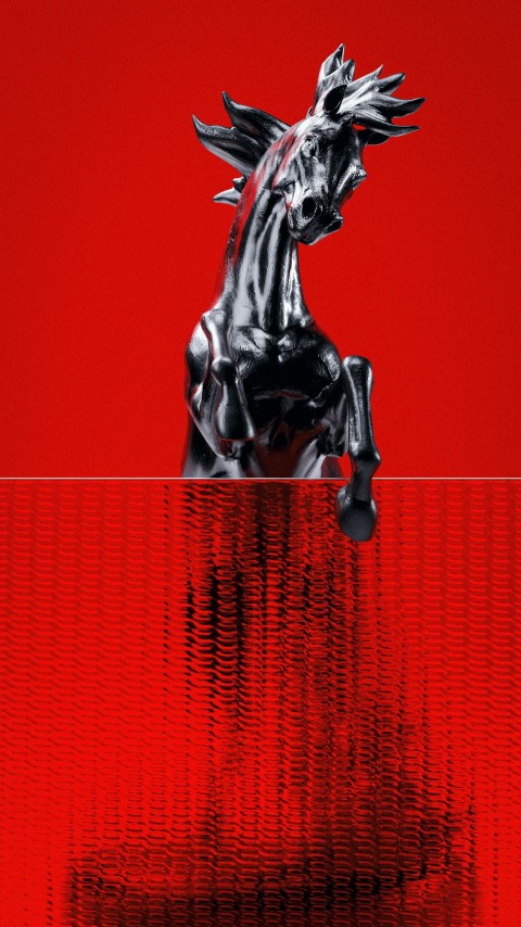 a horse statue on top of a red wall