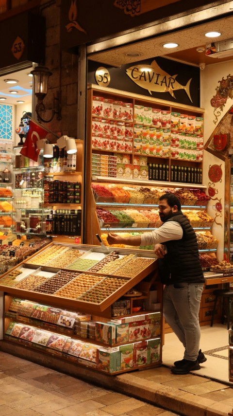 a woman standing in front of a store filled with food