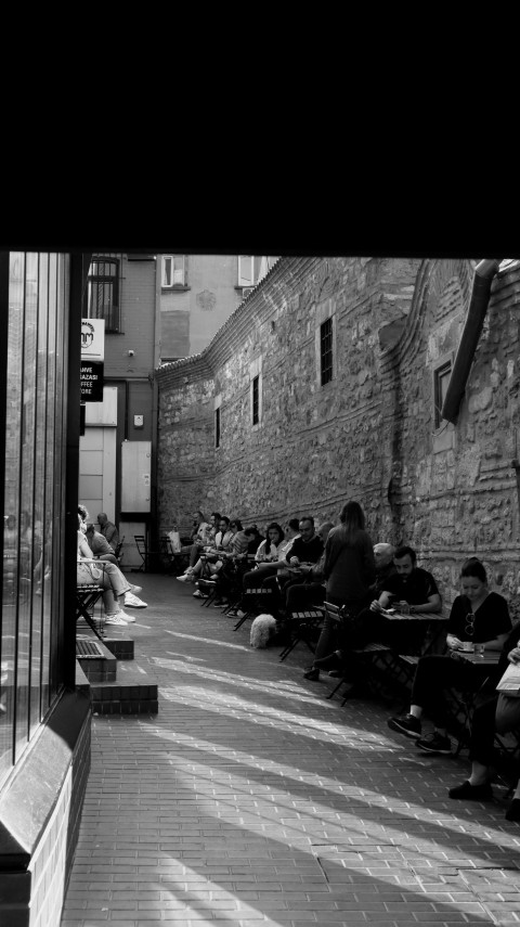 a black and white photo of people sitting on benches