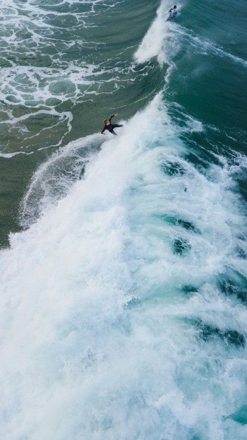 person surfing on sea waves during daytime