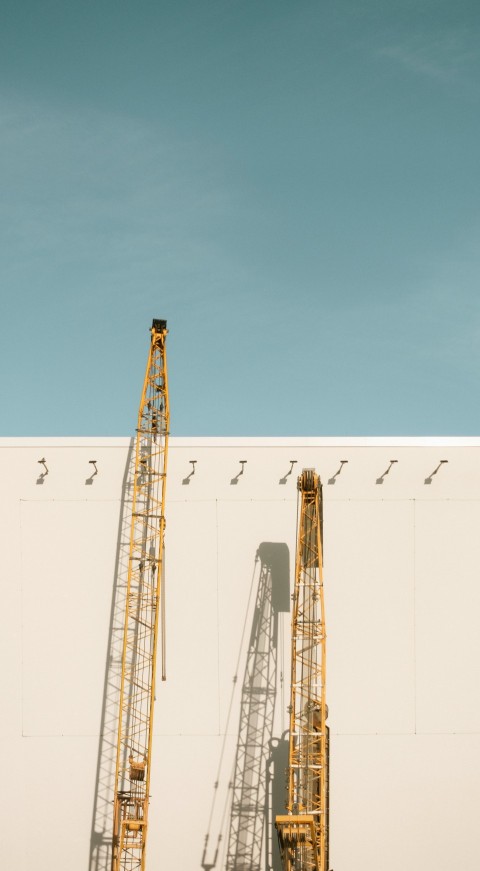 two yellow metal cranes