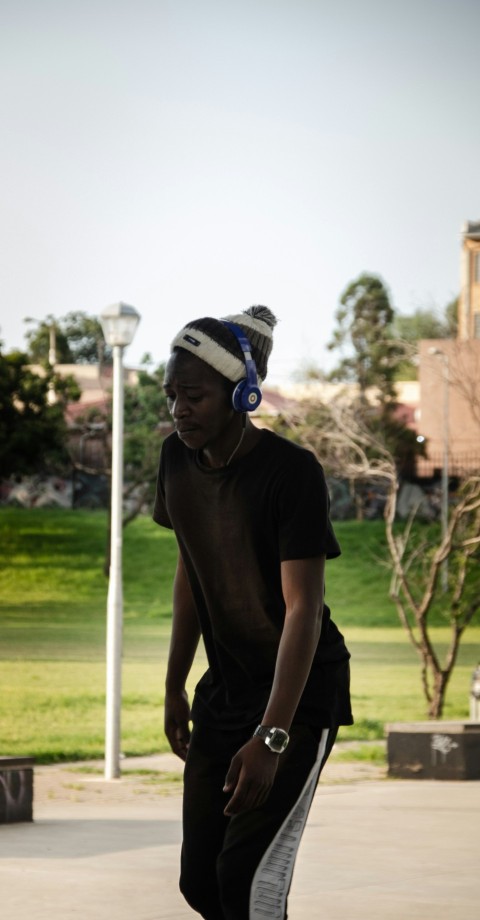 man in black crew neck t shirt wearing blue and white knit cap