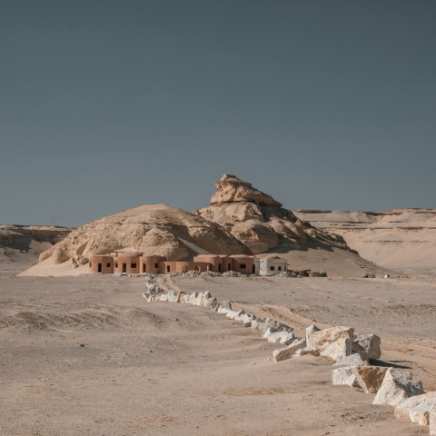 a desert landscape with a building in the middle