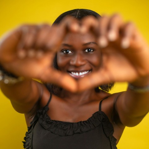 a woman making a heart with her hands mp2VUq