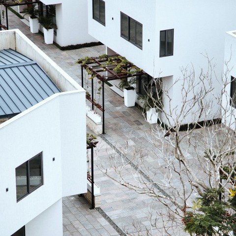 a white building with a black roof and a blue roof