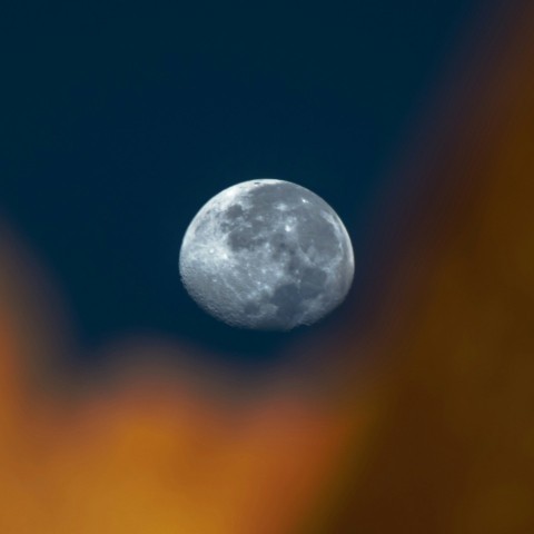 a full moon seen through the clouds in the night sky