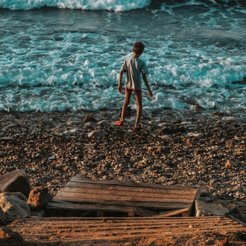 woman in white shirt standing on brown wooden dock near body of water during daytime