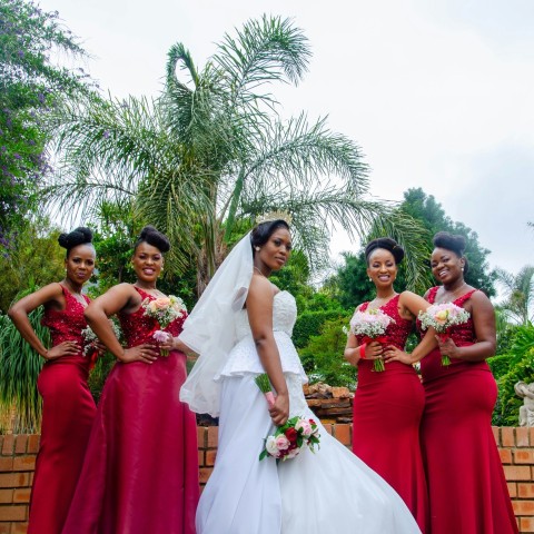 woman in red dress holding bouquet of flowers