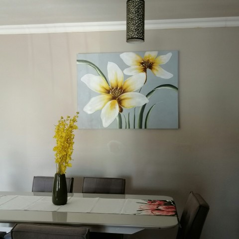 white and yellow flower in black vase on white table yT