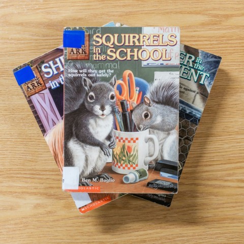 a stack of magazines sitting on top of a wooden table