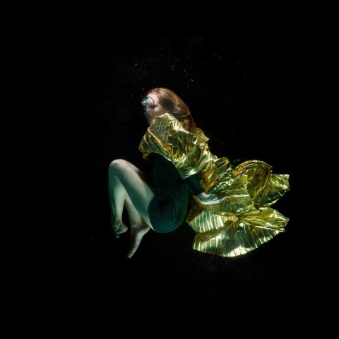 woman in green dress lying on black surface 5