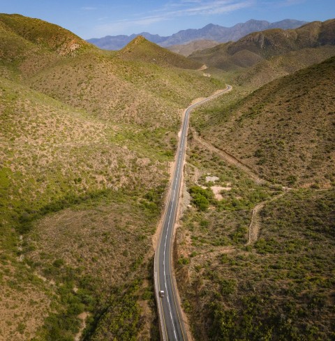 an aerial view of a road in the mountains w