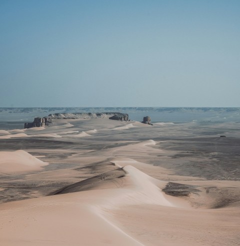 a desert landscape with rocks and sand dunes